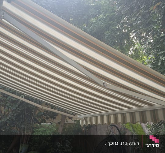 סוכך זרועות בגינה עם צמחייה מסביב